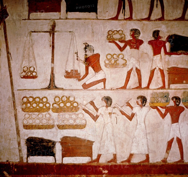 A detail of a wall painting in the tomb of Panekhmen depicting metal workers weighing gold on scales