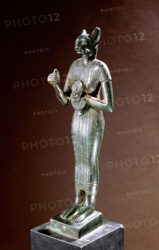 Bronze figure of the cat goddess Bastet, standing with raised right arm, holding a leonine headed aegis