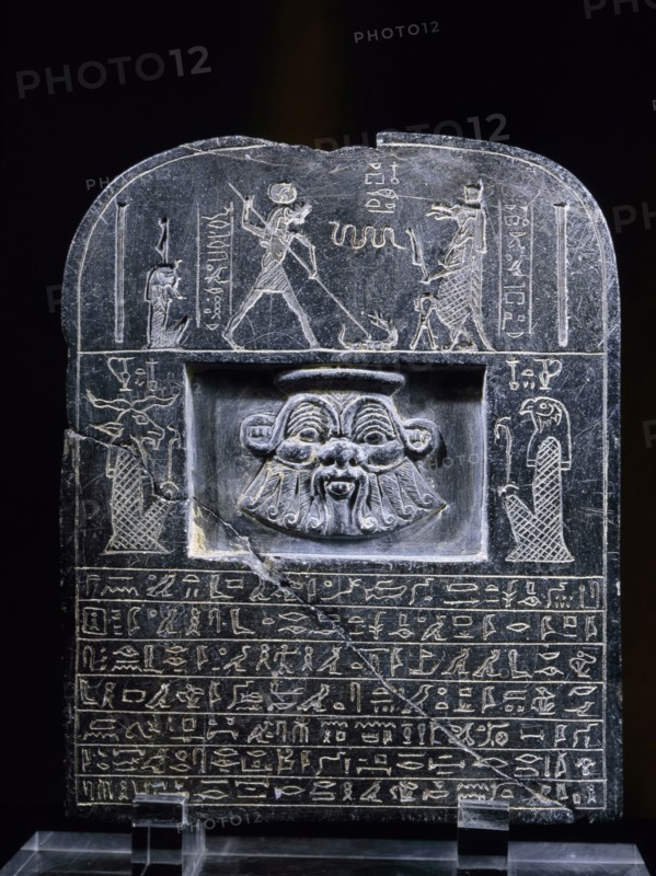 Reverse view of Horus stele, with relief mask of the god Bes, above a hieroglyphic text