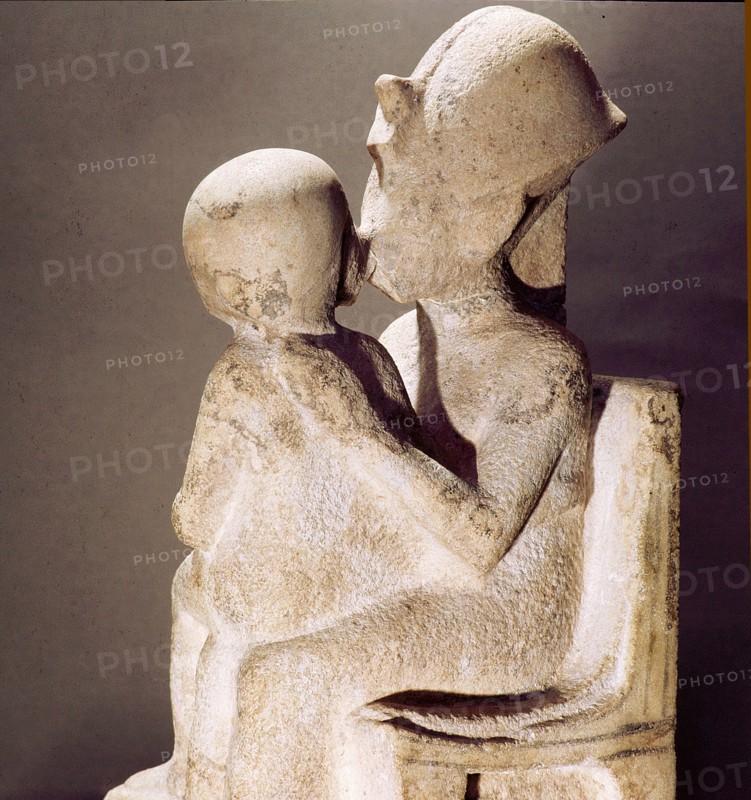 Akhenaton kisses his daughter as she sits on his lap