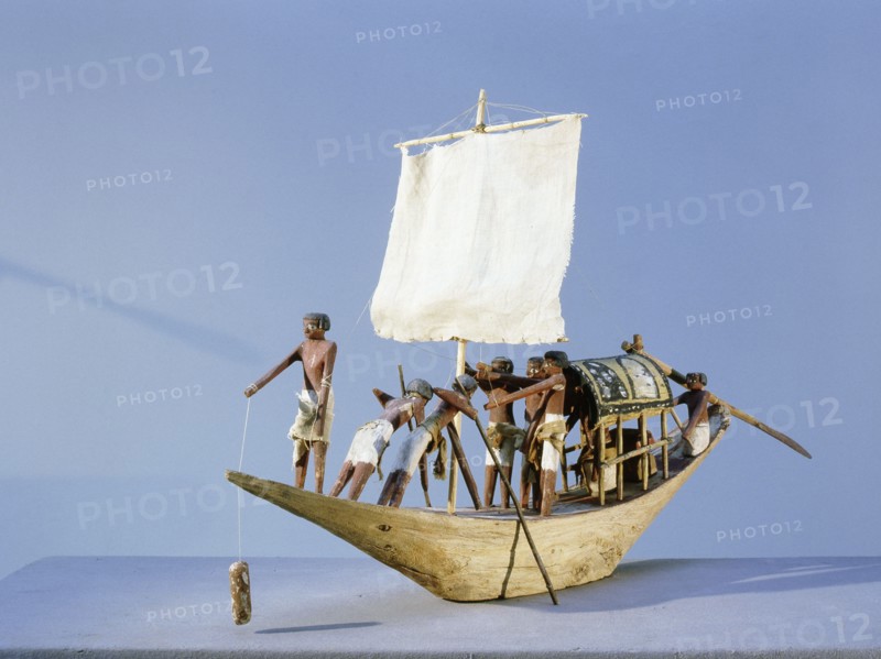 A model of a sailing boat with the pilot in the bow and the owner resting under a canopy