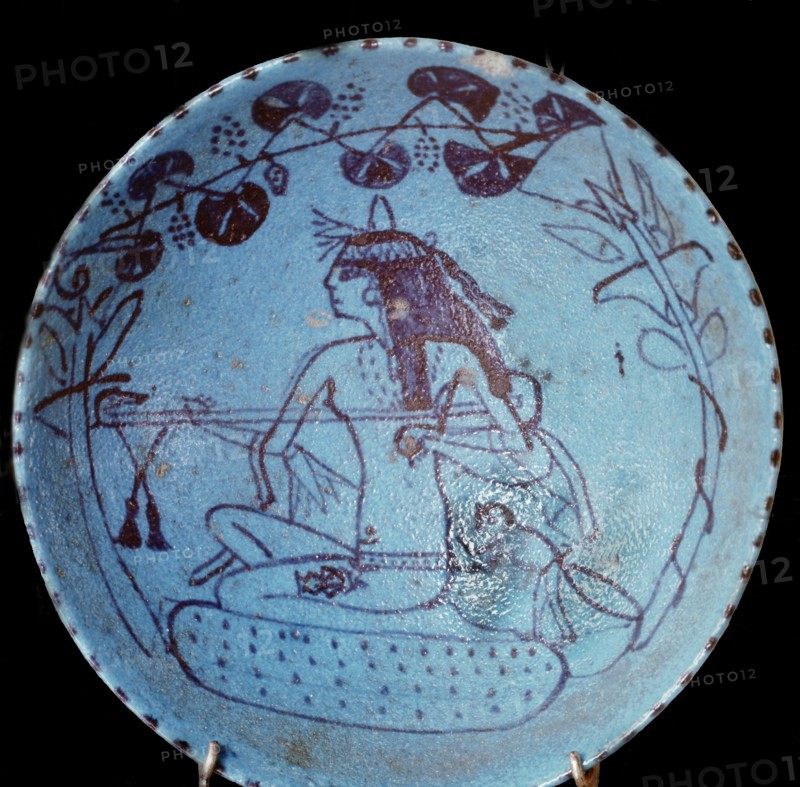 A faience dish decorated with a design of blossoms and a girl playing the lute