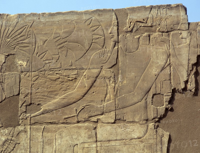 Relief from the walls behind the processional colonnade of Amenophis III depicting Tutankhamun offering flowers to a seated deity