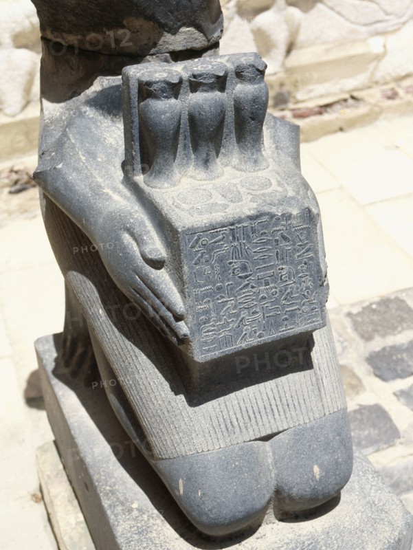 Lower portion of a kneeling sculpture of the physician Horkheb, presenting an offering table bearing hes vases