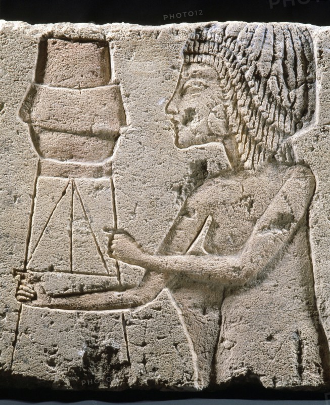 An Amarna relief showing a figure carrying an offering vessel