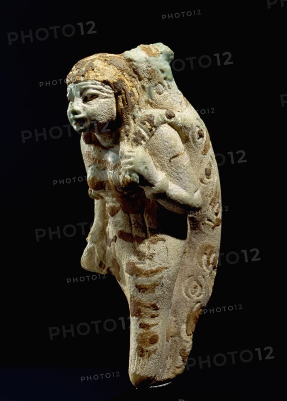 Ceramic figure of a woman carrying an animal, thought to be a leopard, on her back