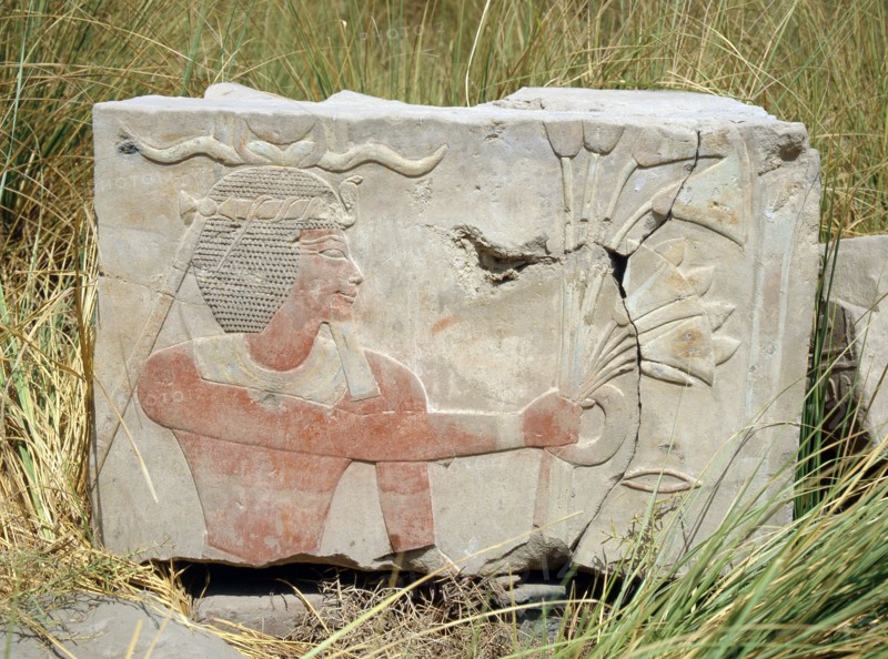 Block from a painted relief depicting a king with a rams horn headdress presenting an offering of flowers