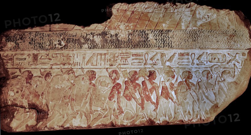 Block from a painted relief showing a parade of soldiers carrying shields,lances and sickles