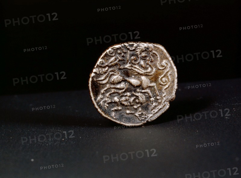 Low alloy coin showing a human headed horse guided by a person waving a torque