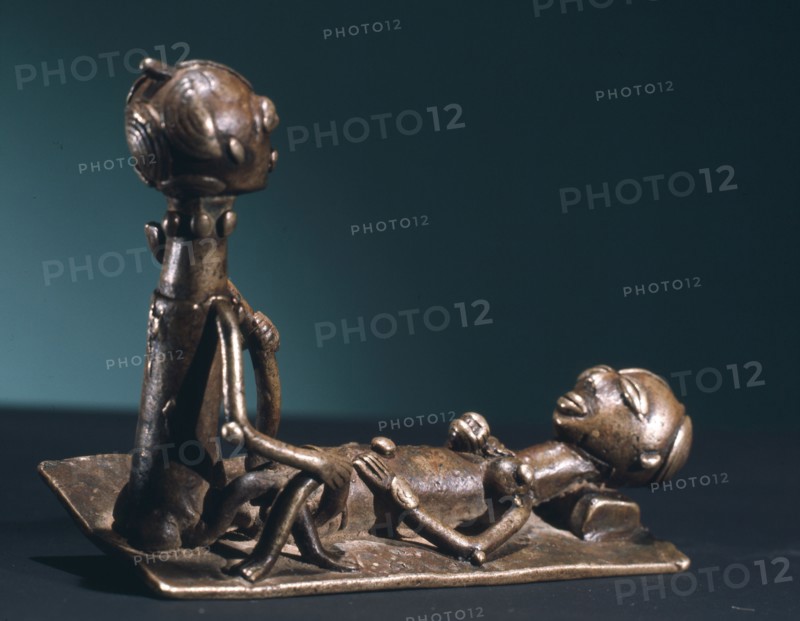 A brass weight which was used for weighing gold dust, representing a man and woman during sexual intercourse