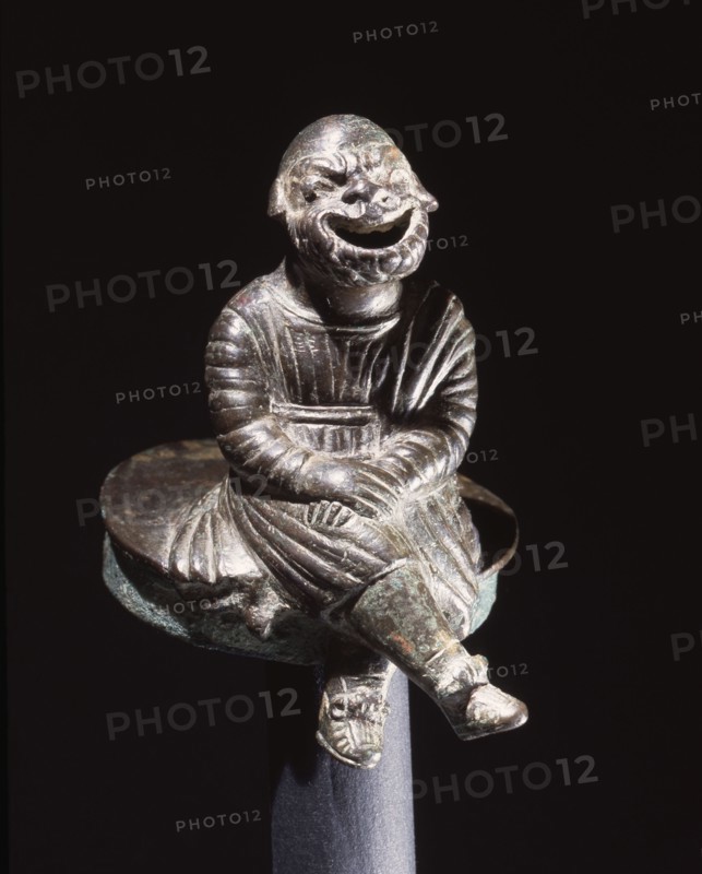 Bronze figure of a comic actor seated on a cylindrical lid, possibly from an incense burner