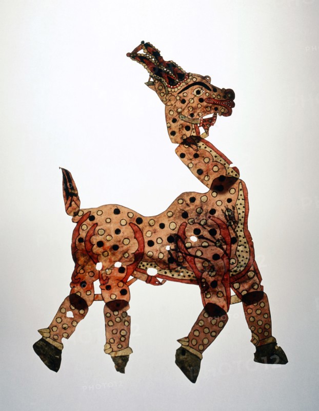 A shadow puppet in the form of a yellow prancing horse, decorated with black and white spots