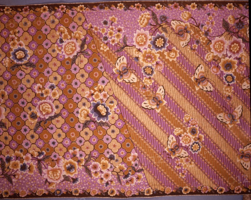 A batik sarong with a design of butterflies and flowers over a simplified version of the scrolled background motif known as parang