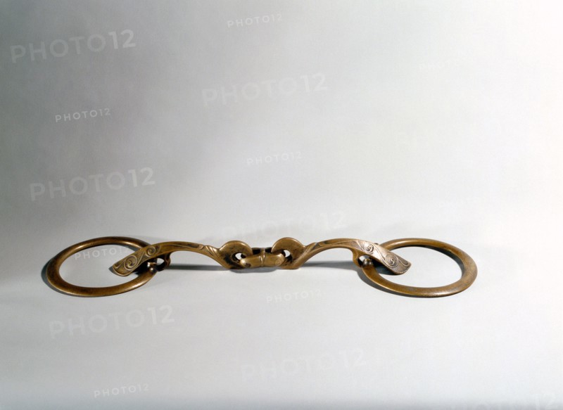 One of a pair of bronze bridle bits, found in a peat bog
