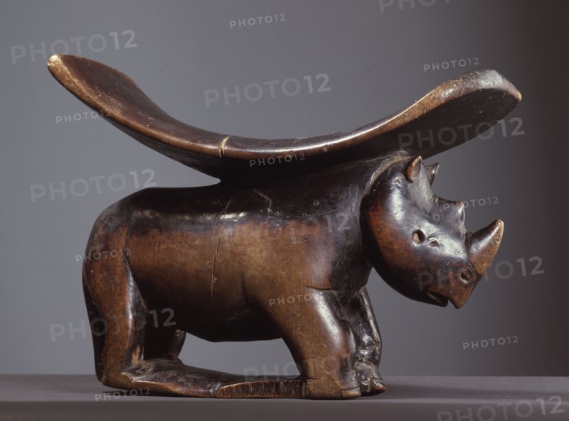 A headrest with support carved as a rhinoceros
