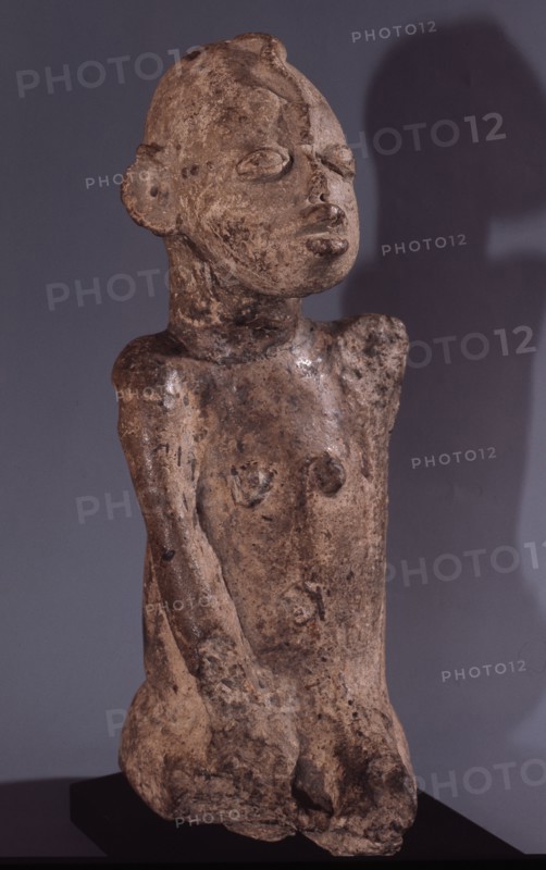 A terracotta figure with a snake curling down the forehead