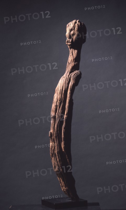 A wood sculpture of a man, possibly an ancestor figure