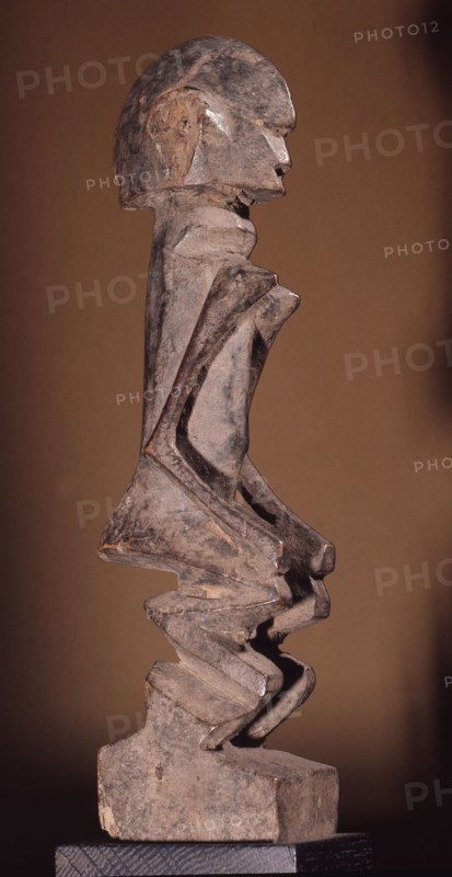 A wood sculpture of a woman, possibly an ancestor figure
