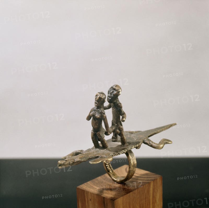 A finger ring in the form of a man with erect phallus and a woman on the back of a crocodile