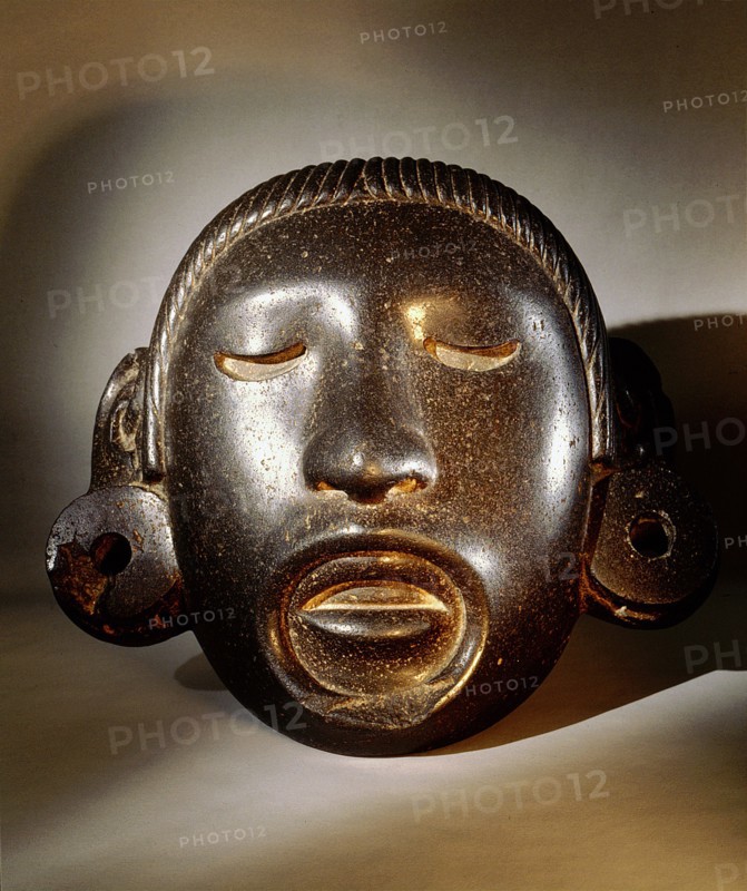 Stone mask of Xipe Totec, the Flayed Lord, dressed in the skin of a sacrificial victim