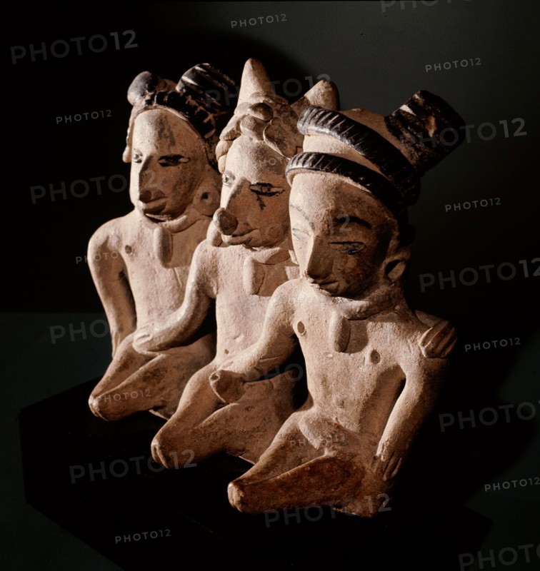 Three seated figures, a man flanked by two women