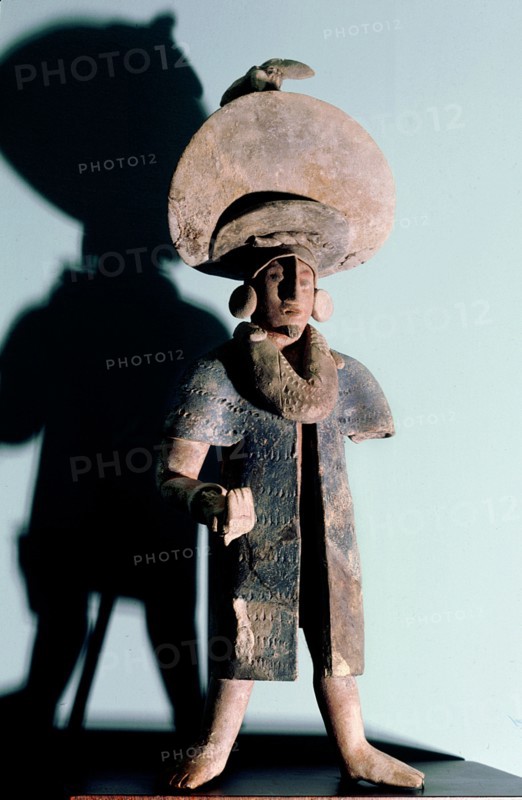 Figurine of a man wearing a large hat, possibly a priest