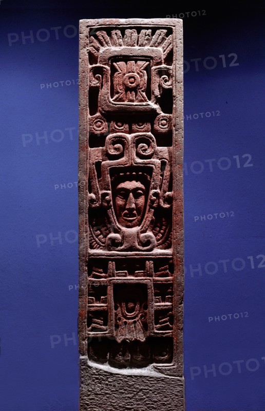 Stone column depicting Quetzalcoatl as Morning Star emerging from the jaws of a serpent   its forked tongue can be seen lolling from its lower jaw