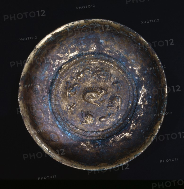 Inside view of gilt bronze bowl decorated with the heads of four mythical water beasts pursuing ducks and fish