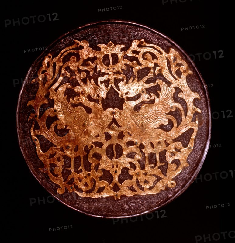 The reverse of a mirror decorated in relief with a pair of phoenixes and yin yang symbols