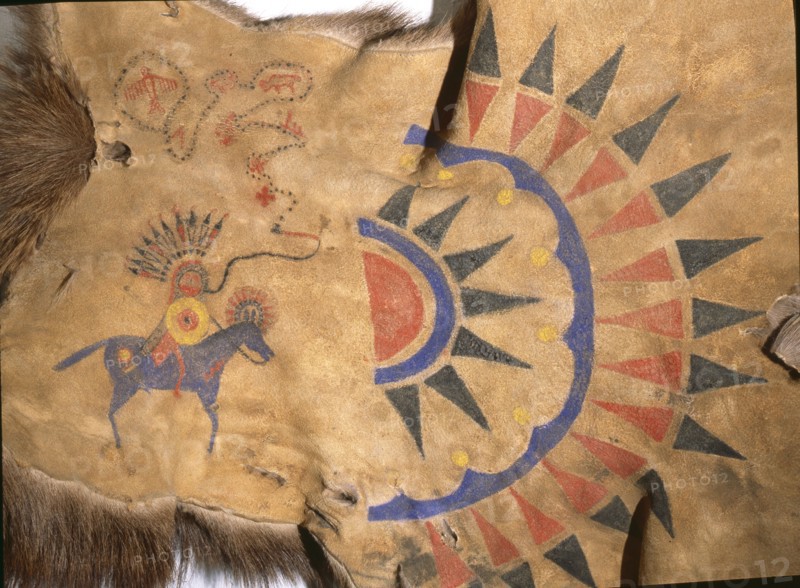 Hide painting depicting the sun burst design and a pictograph of an individuals exploits