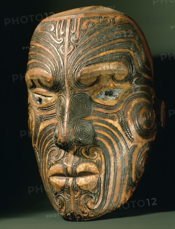 A carved wood Maori head with inlaid shell eyes