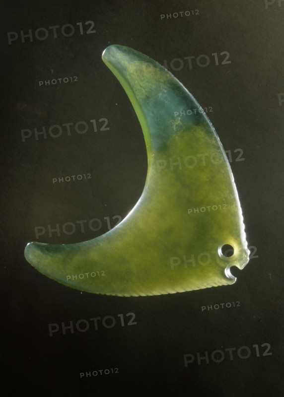 An amulet in the form of a green stone semi translucent fish