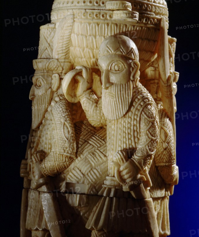 An ivory salt cellar around the base of which are figures of Portuguese noblemen