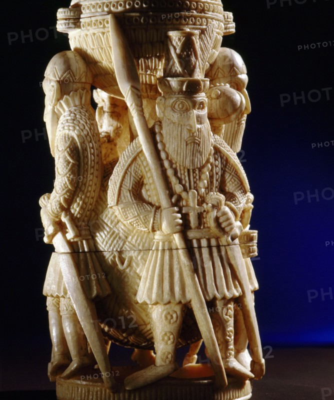 An ivory salt cellar around the base of which are figures of Portuguese noblemen