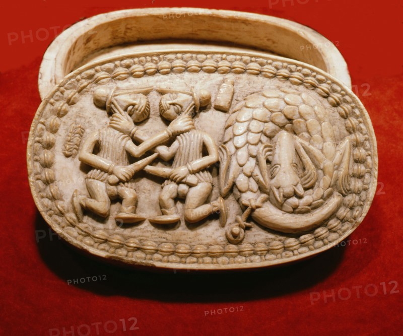 A Benin ivory box showing two Portuguese soldiers fighting beside a slaughtered dragon, the latter probably copied from a European print