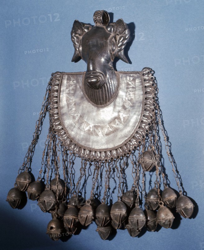 A brass pectoral ornament, part of a chiefs regalia, depicting a rams head
