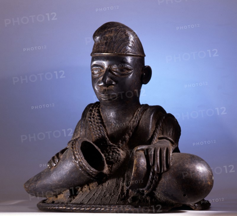 An unusual Yoruba carving of a man, probably a hunter carrying containers for medicines collected in the bush