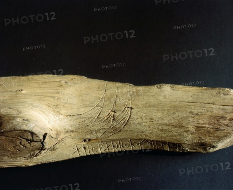 Three Viking ship prows incised on a piece of wood