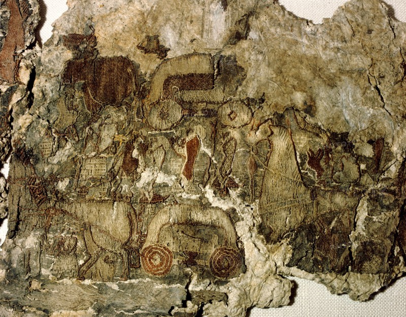 Oseberg tapestry fragment with a design of men, horses and carts