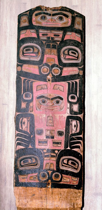A carved and painted cedar board with a design showing ancestry and social position