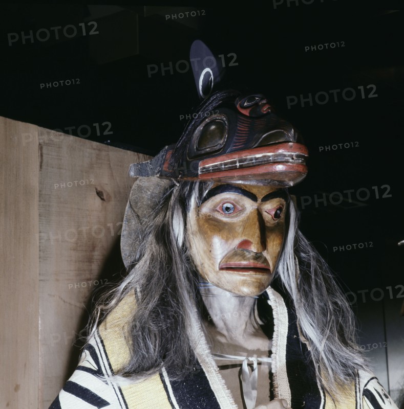 Carved and painted figure of a shaman wearing ritual robes and a headdress
