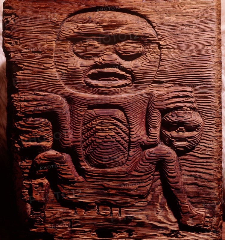 A cedar box carved in relief with a shaman displaying human heads