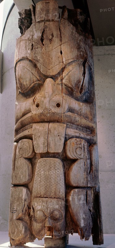 Frontal house post carved with a beaver which can be identified by its prominent teeth and scaly cross hatched tail