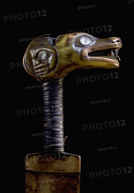 The handle of an iron bladed knife carved with a representation of the wolf totem