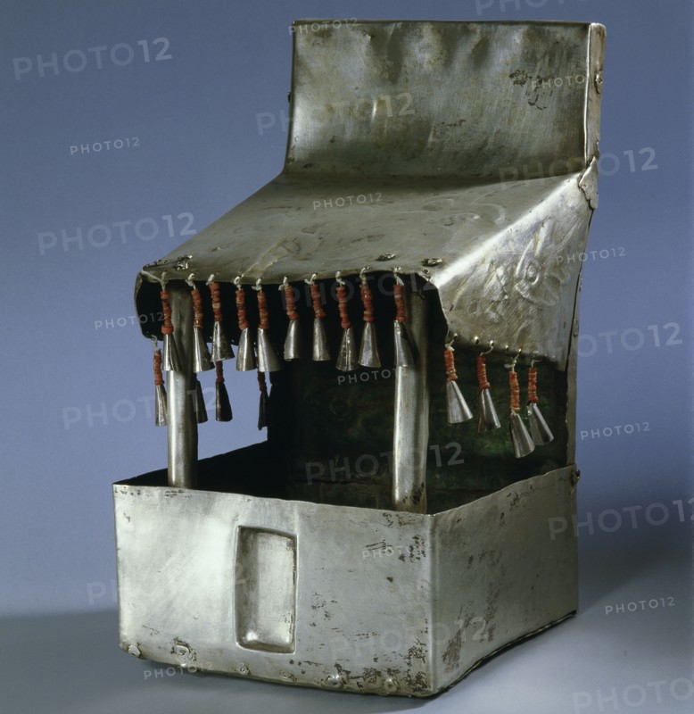 A model temple made of beaten silver, with bell like tassels hanging from the roof