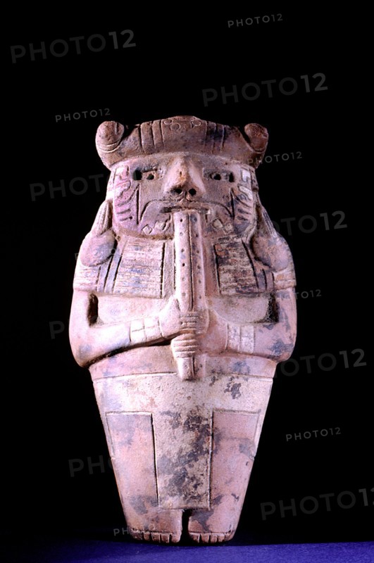 Hollow ceramic effigy flute player wearing jaguar headdress