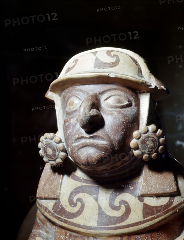 Detail of a Mochica effigy jar showing a high status individual wearing an elaborate headdress and two large ear discs
