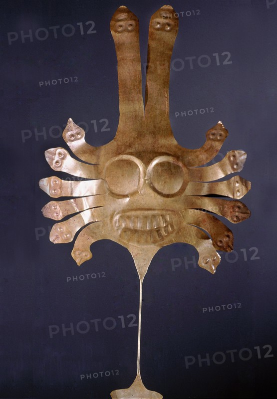 Nazca dance wand of hammered gold with a stylized feline face surrounded by machakway serpents