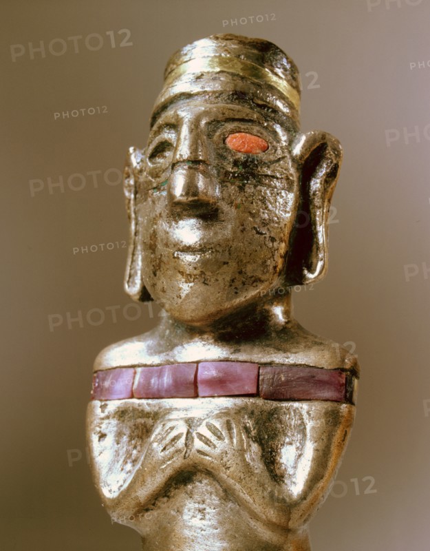 Male figurine cast in silver with unusual inlay of gold, stone and pink shell