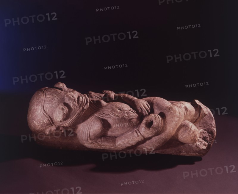 A soapstone nomoli depicting a woman with body scarifications, lying on her back